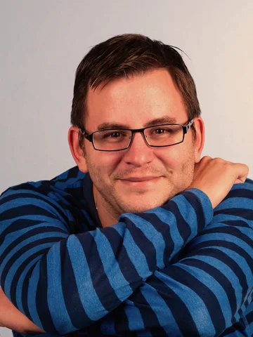 Mann mit Brille und blau gestreiftem Hemd