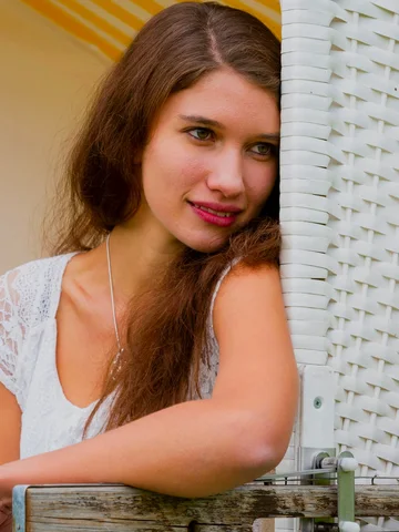 Frau mit langem braunem Haar und weissem Spitzentop